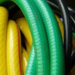 Hiverner son arrosage : tuyau d'arrosage vert, jaune et noir enroulé et rangé à l'abri du gel avant l'hiver