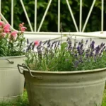 Jardinière d'automne avec des pots fleuris posés dans l'herbe parmi les premières feuilles mortes, ambiance douce de début d'automne